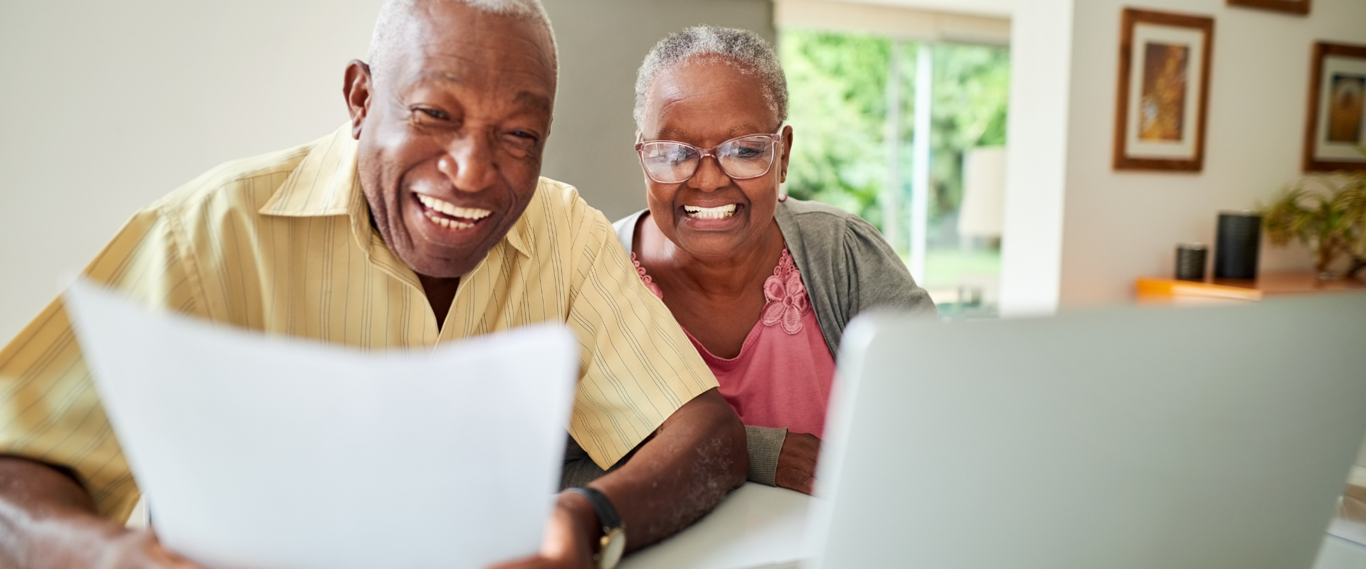 Happy seniors using laptop at home