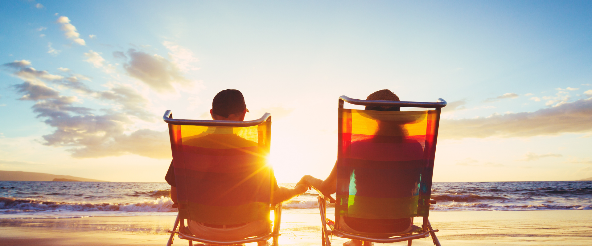 Couple relaxing on beach at sunset