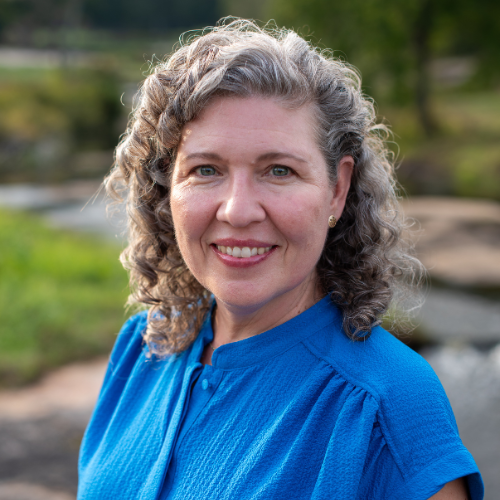 Smiling woman outdoors near a river