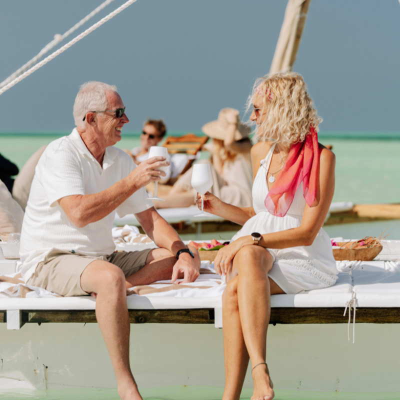 Couple toasting drinks on tropical beach deck